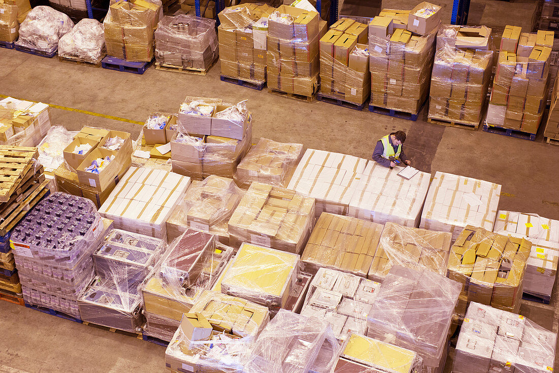 Worker using clipboard in warehouse