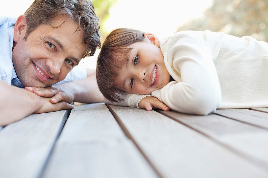 Father and daughter laying on porch