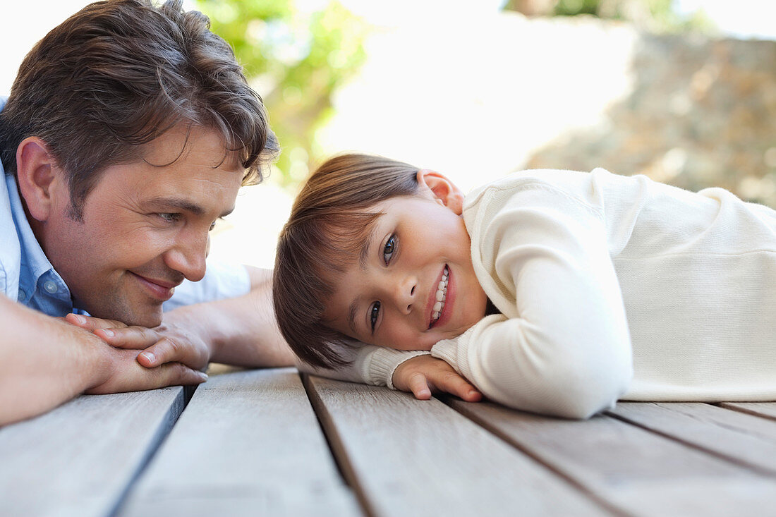 Father and daughter laying on porch