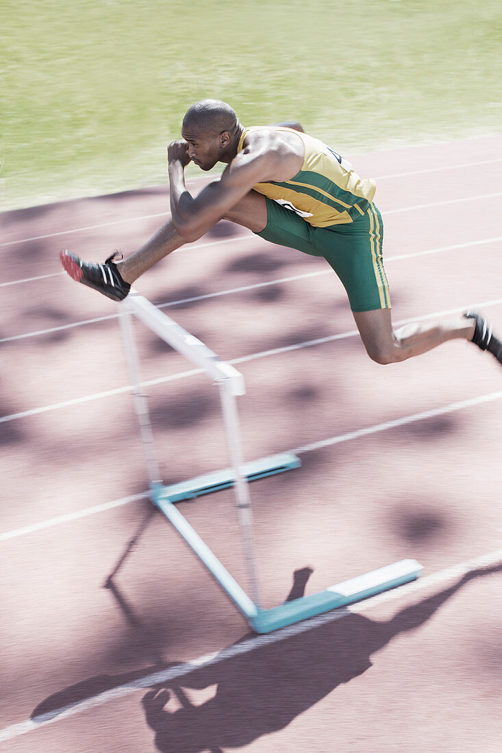 Runner clearing hurdle on track