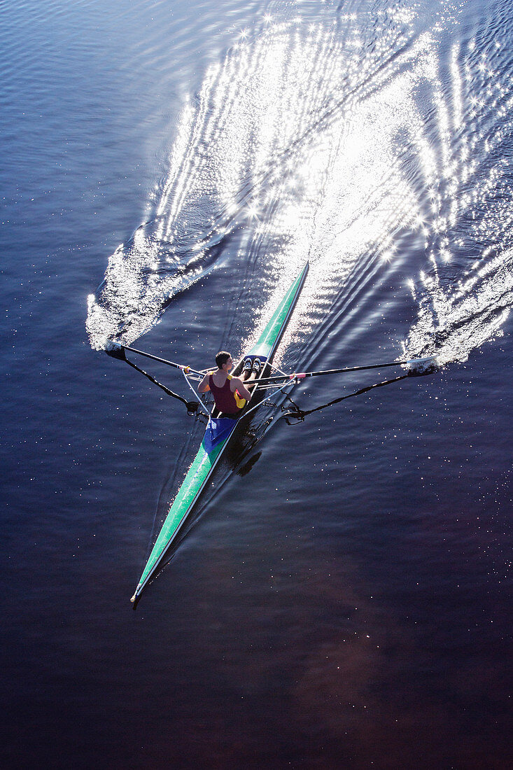 Man rowing scull on lake