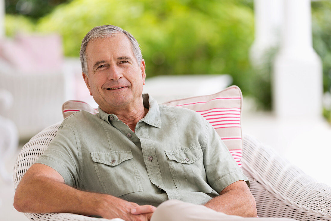 Older man sitting in armchair outdoors