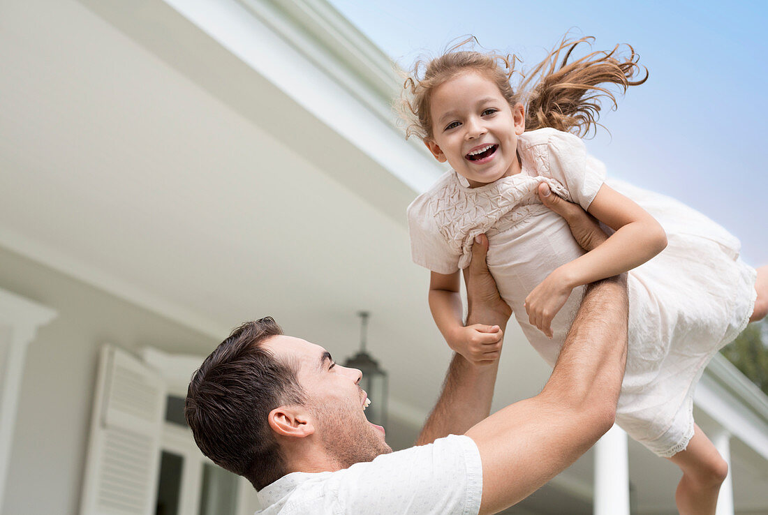 Father and daughter playing outside house