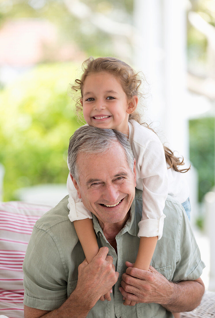 Older man carrying granddaughter