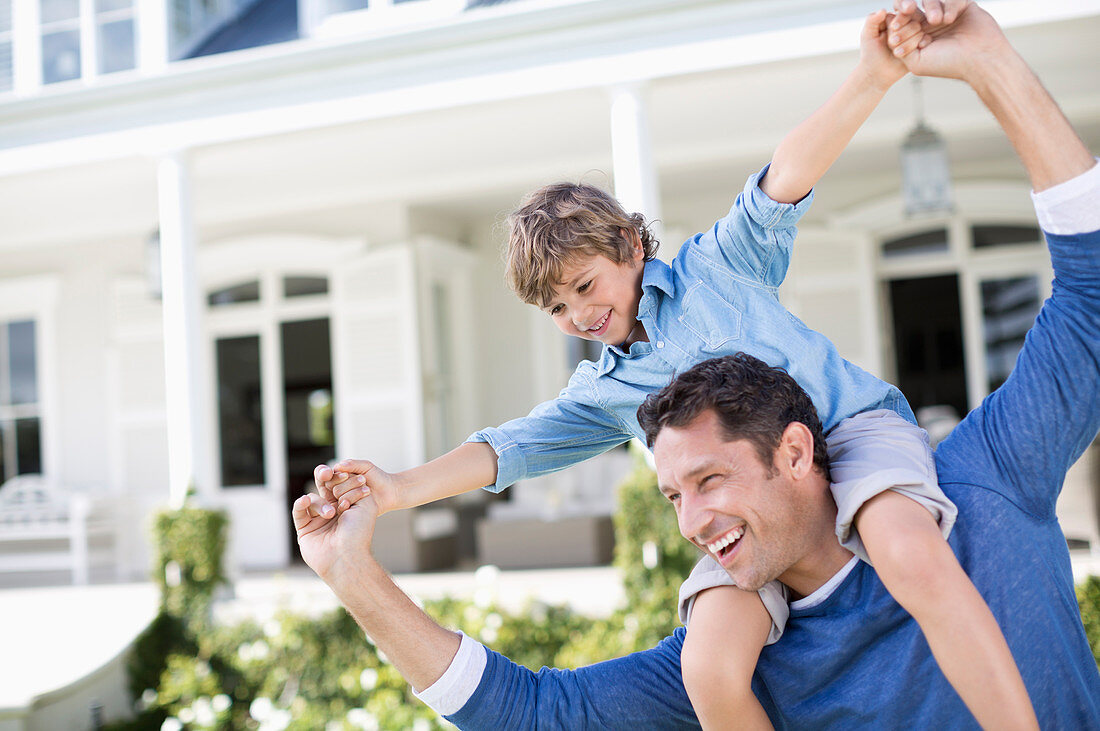 Father and son playing outside house