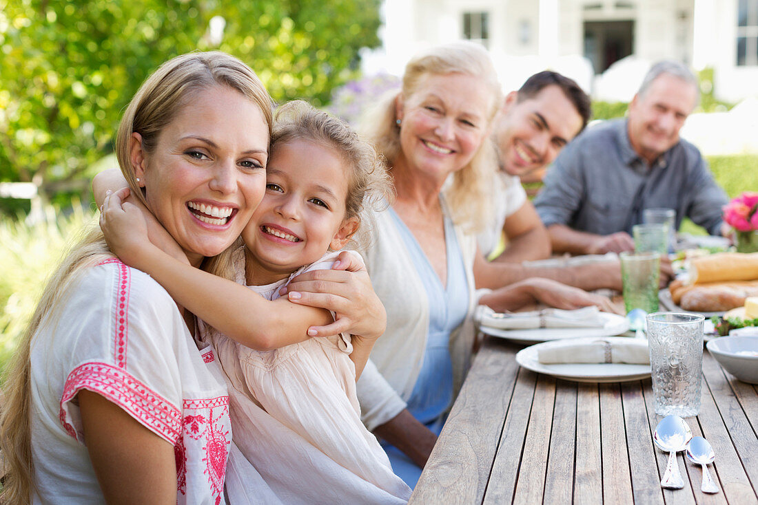 Mother and daughter hugging at table