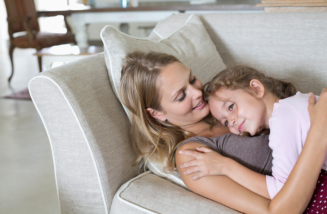 Mother and daughter relaxing on sofa