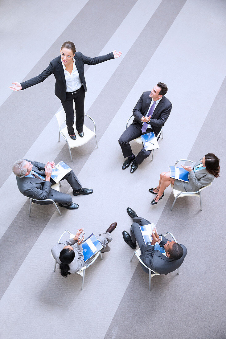 Businesswoman standing on chair