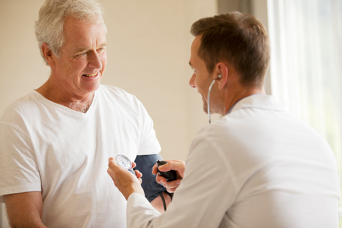 Doctor checking man's blood pressure