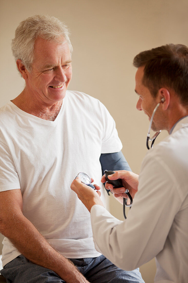 Doctor checking man's blood pressure