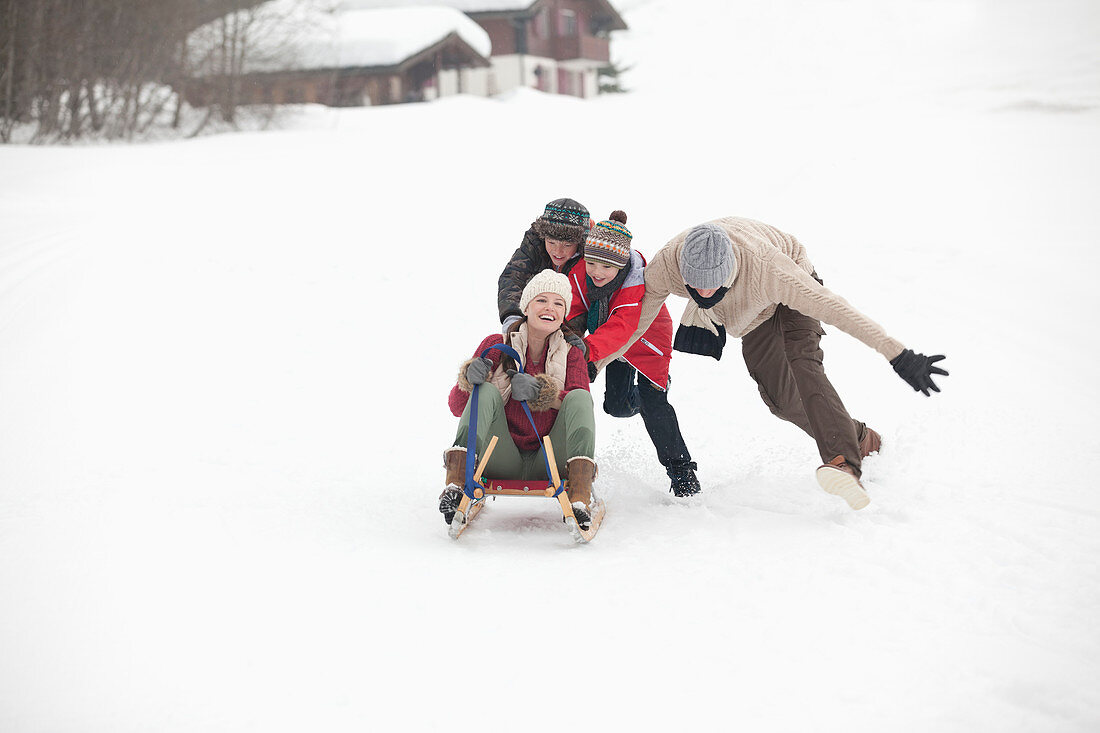 Happy family sledding in snowy field