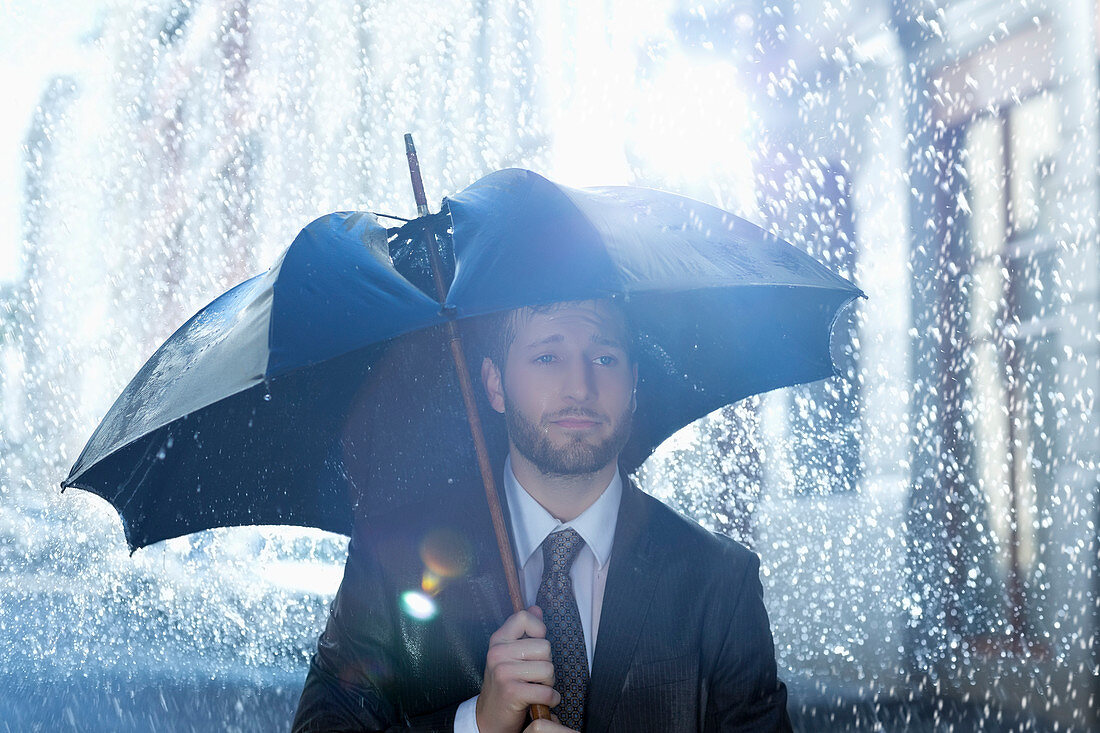 Businessman with broken umbrella