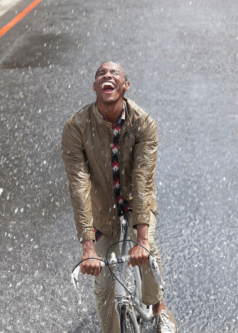 Enthusiastic man riding bicycle in rain