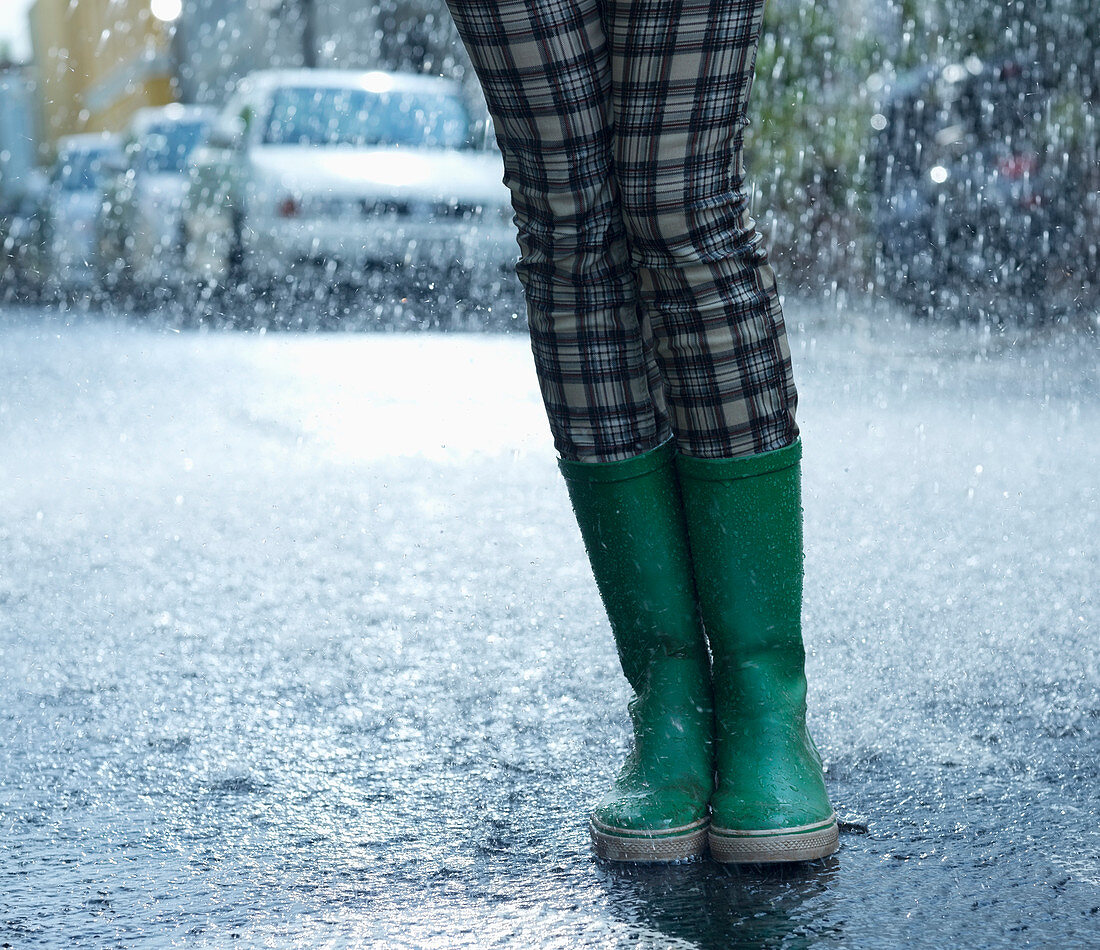 Rain falling around woman in wellingtons