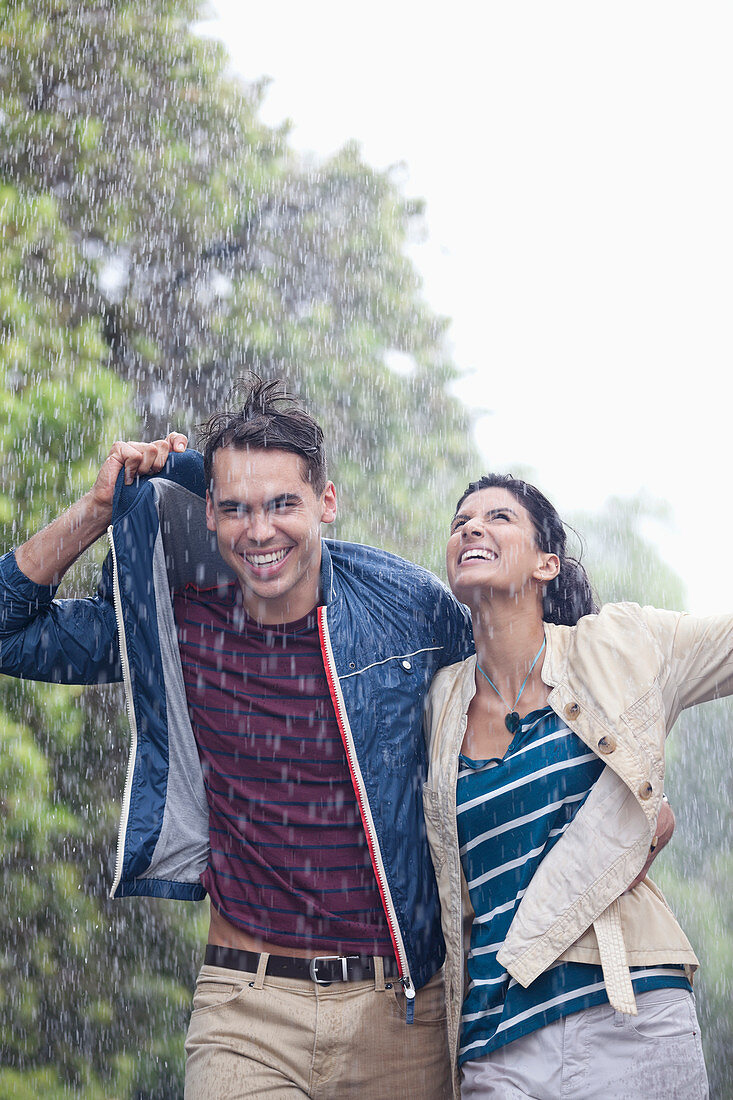 Happy couple walking in rain