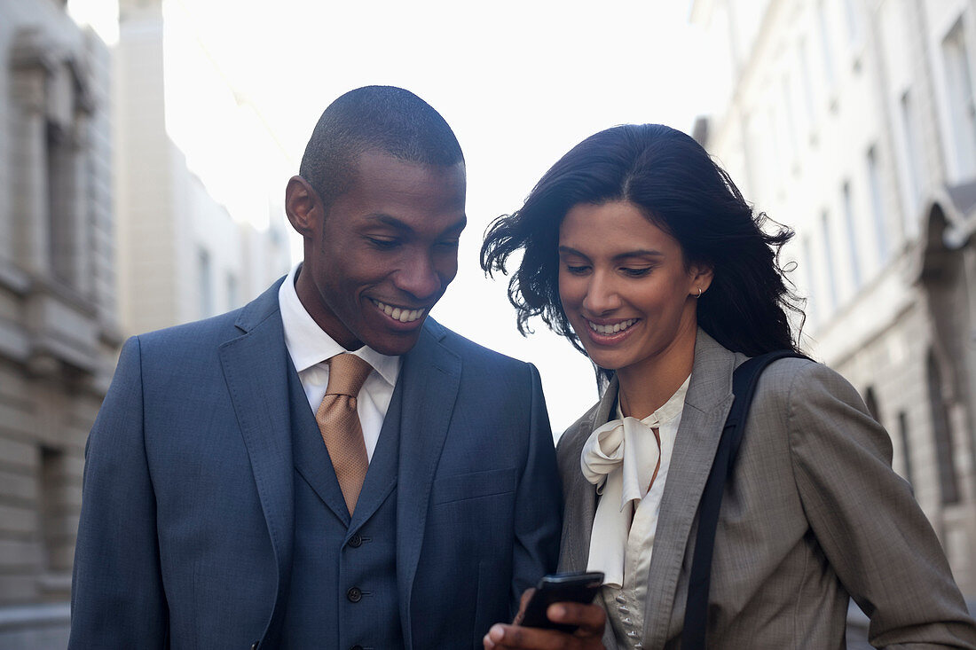 Smiling business people text messaging