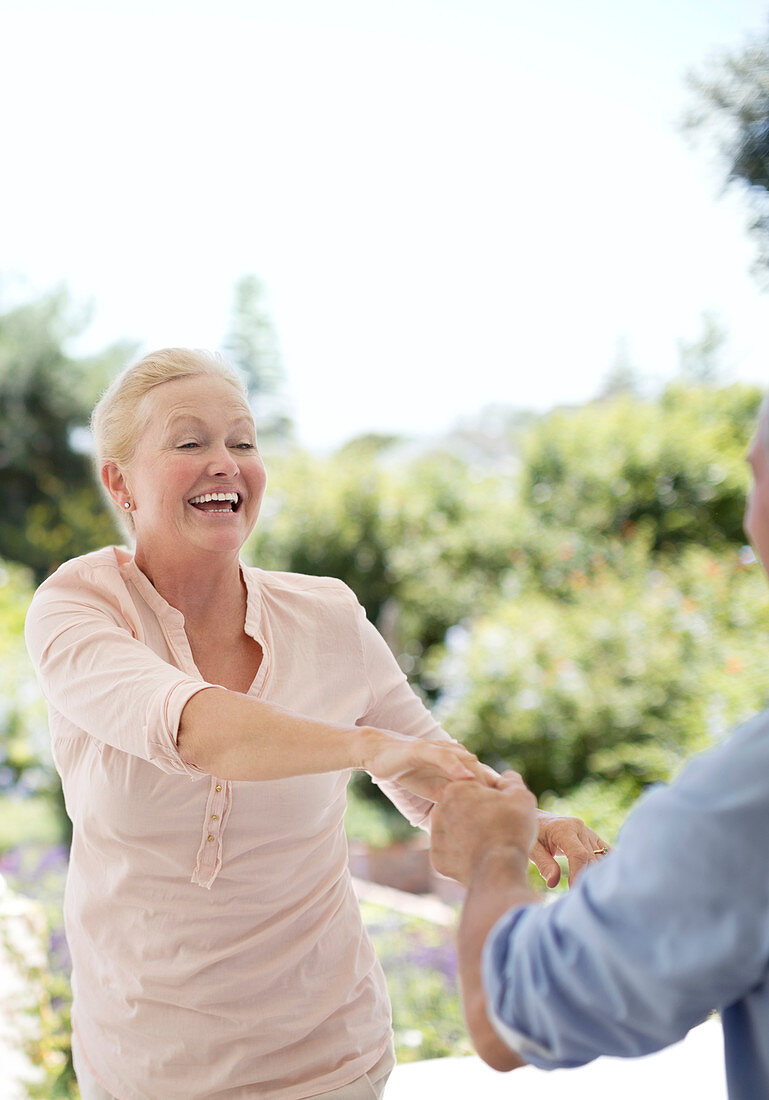 Senior couple dancing on patio