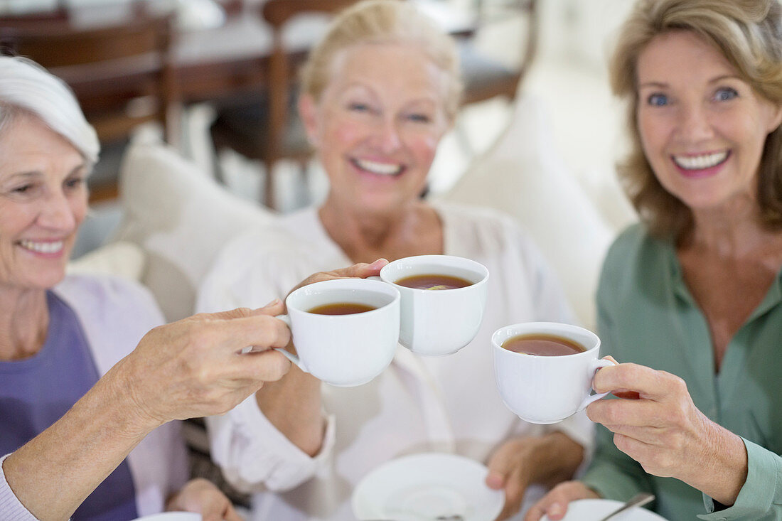 Senior women toasting coffee cups