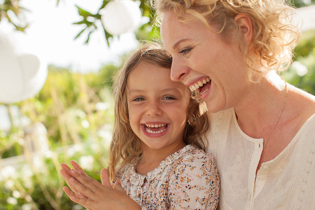 Mother and daughter laughing outdoors