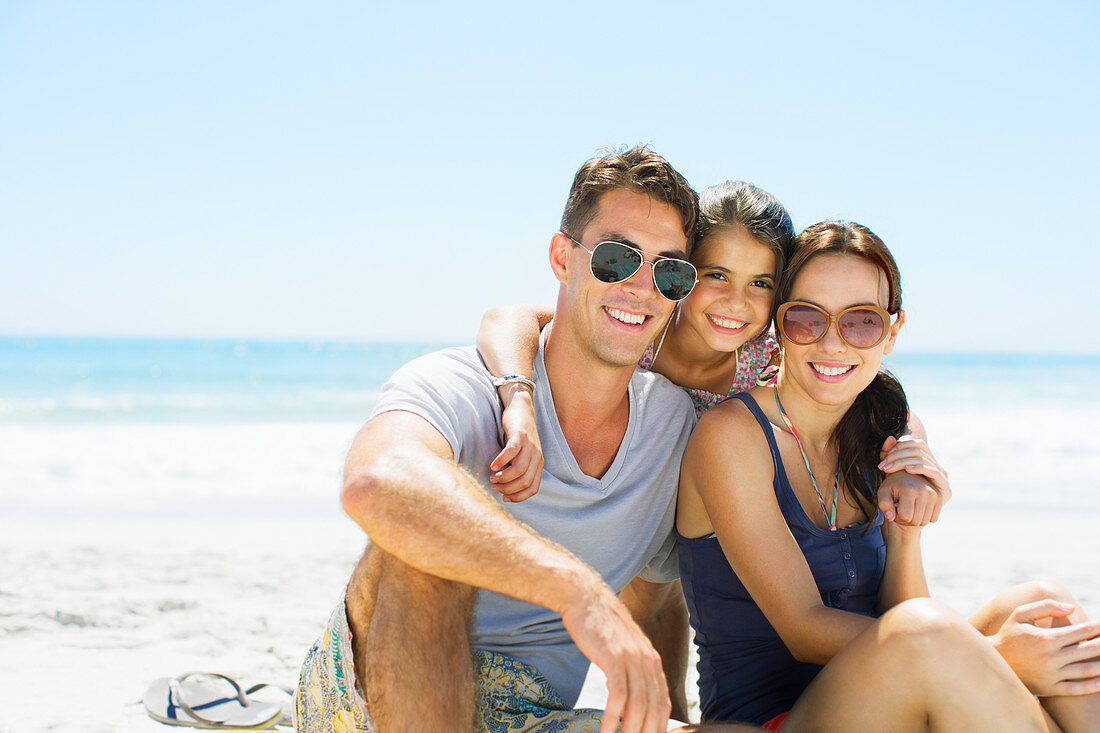 Smiling family hugging on beach