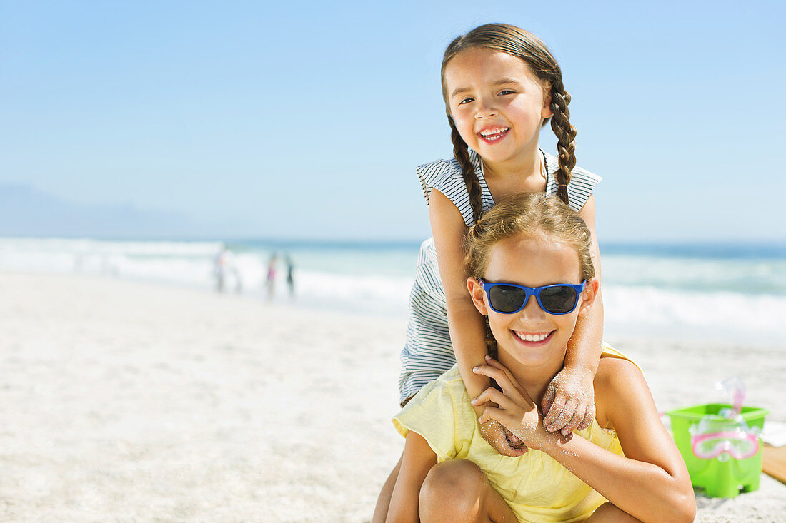 Smiling girls hugging on beach