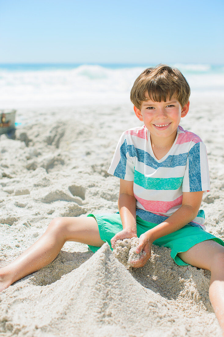 Boy building sandcastle on beach