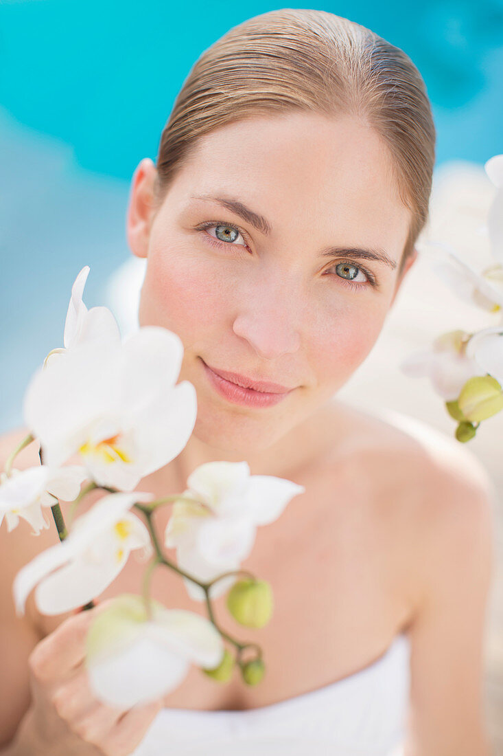 Woman holding flower poolside