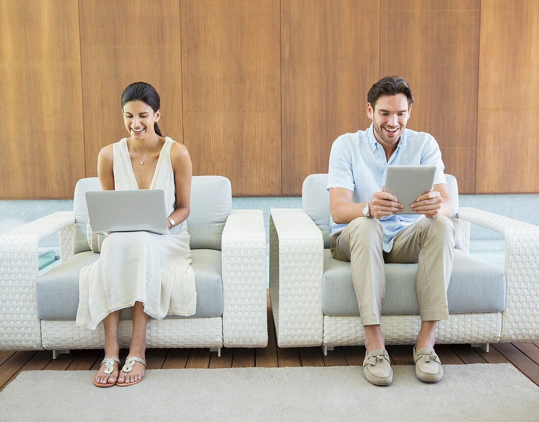 Couple using laptop and tablet