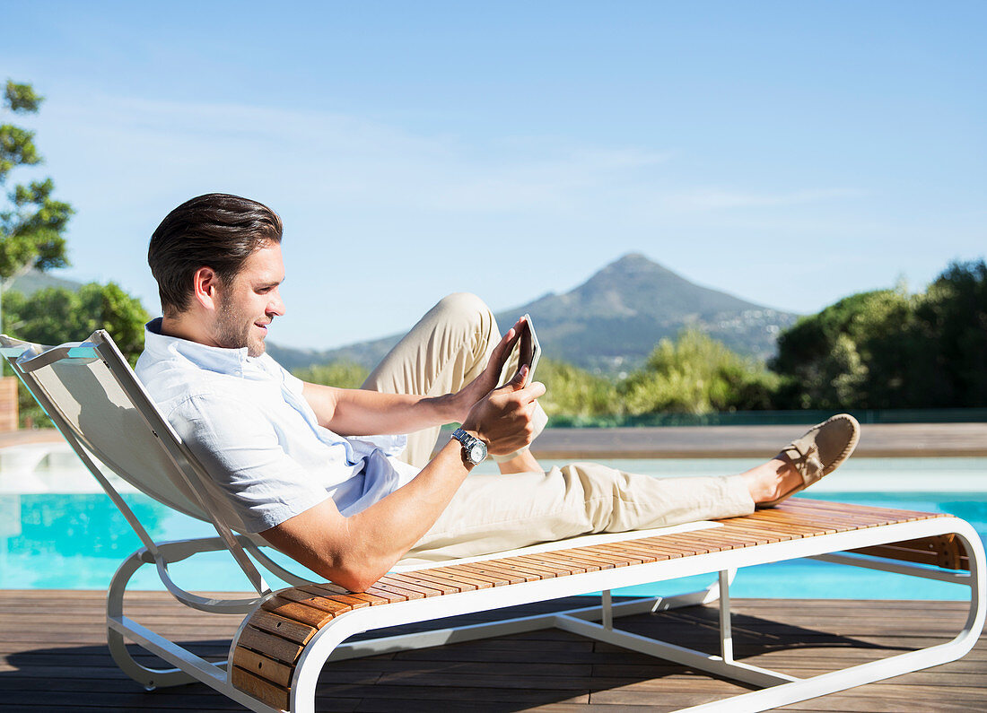 Man using tablet at poolside