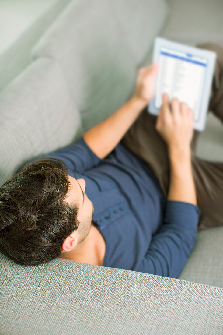 Man using digital tablet on sofa