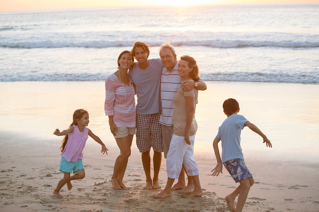 Multi-generation family hugging on beach