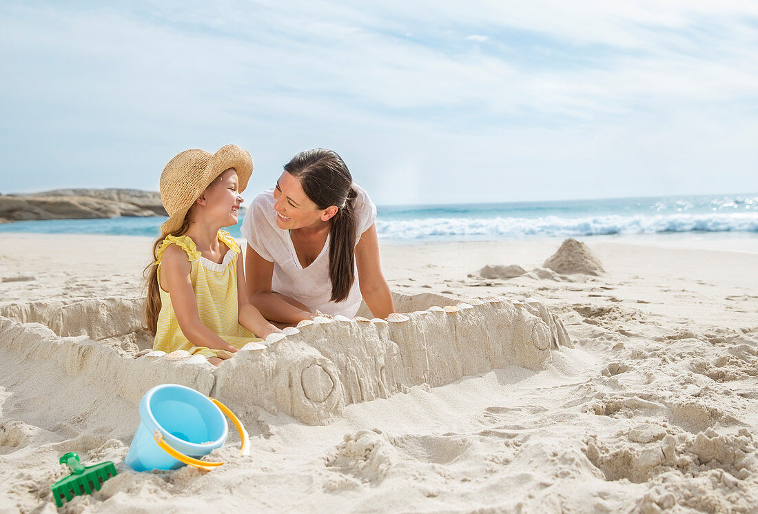 Mother and daughter making sandcastle