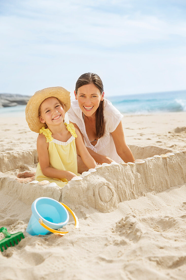 Mother and daughter making sandcastle