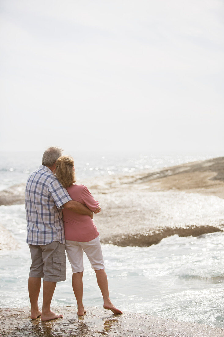 Older couple hugging on beach