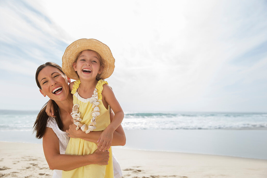 Mother and daughter laughing on beach