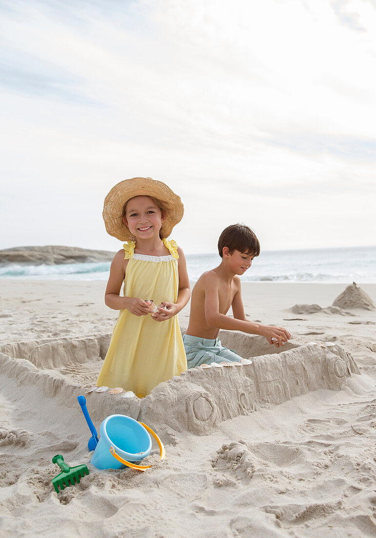 Children building sandcastle on beach