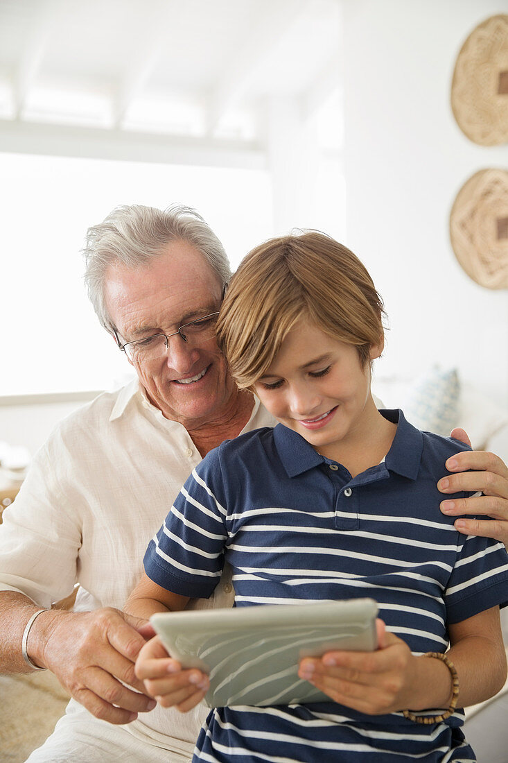 Older man and grandson using tablet