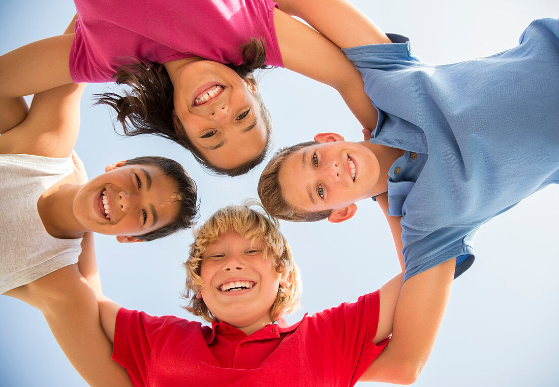 Children smiling in huddle outdoors