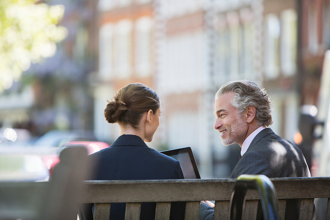 Business people talking on urban bench