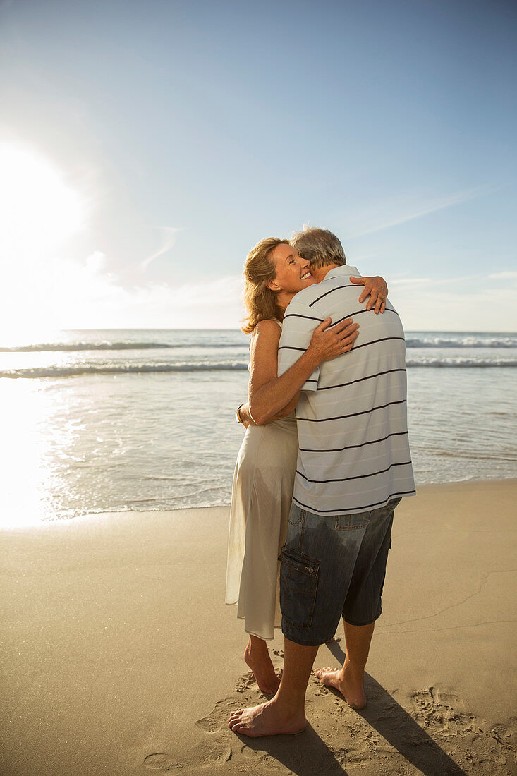 Older couple hugging on beach