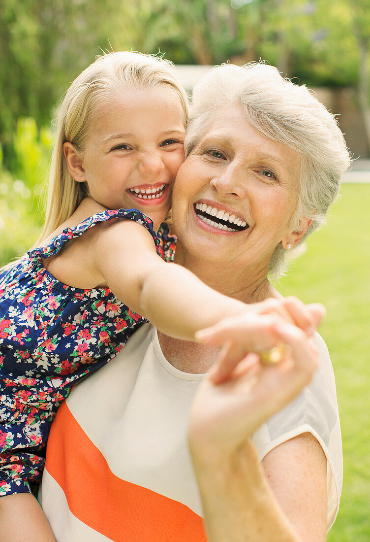 Smiling grandmother holding granddaughter