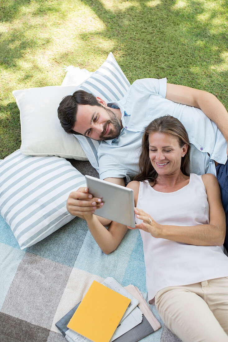 Couple using digital tablet outdoors