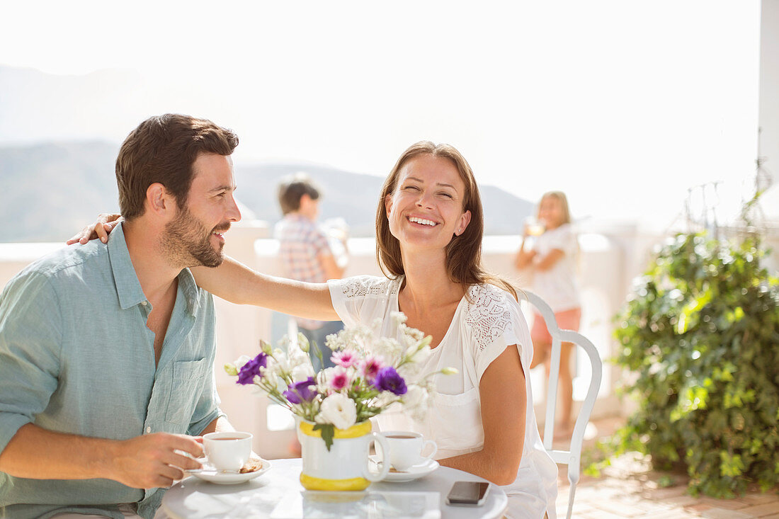 Couple enjoying coffee on balcony