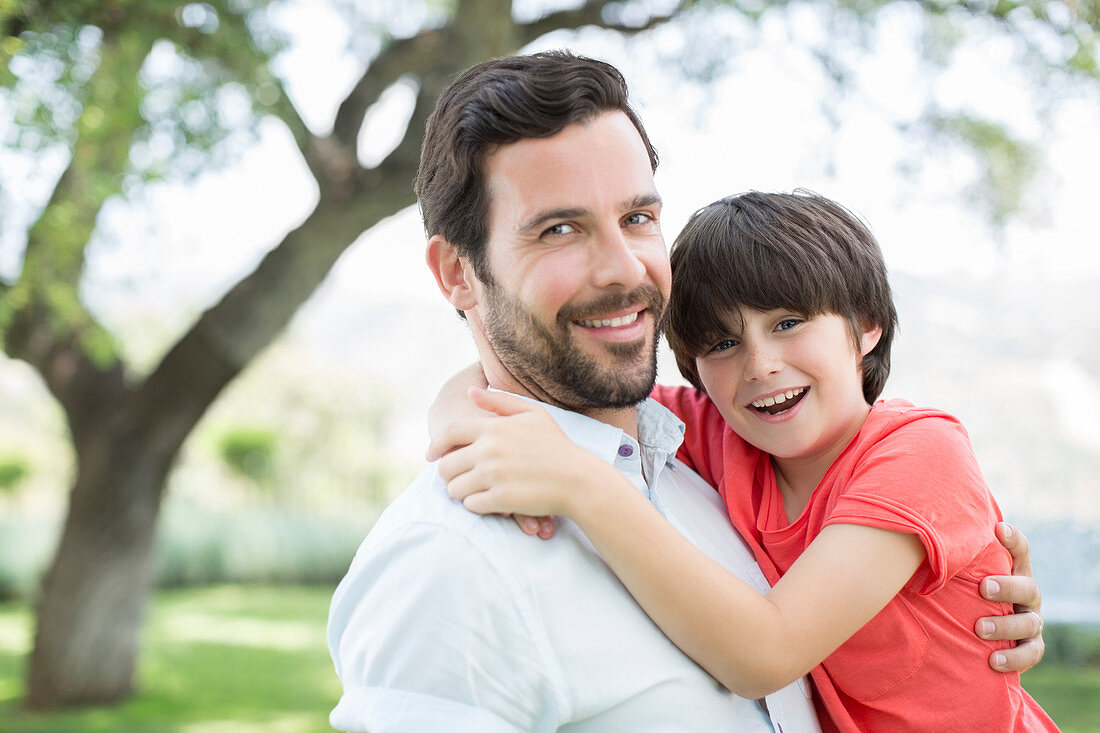 Father and son smiling outdoors