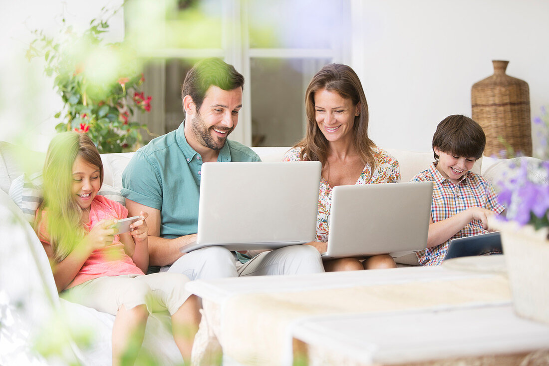 Family with laptops and cell phone