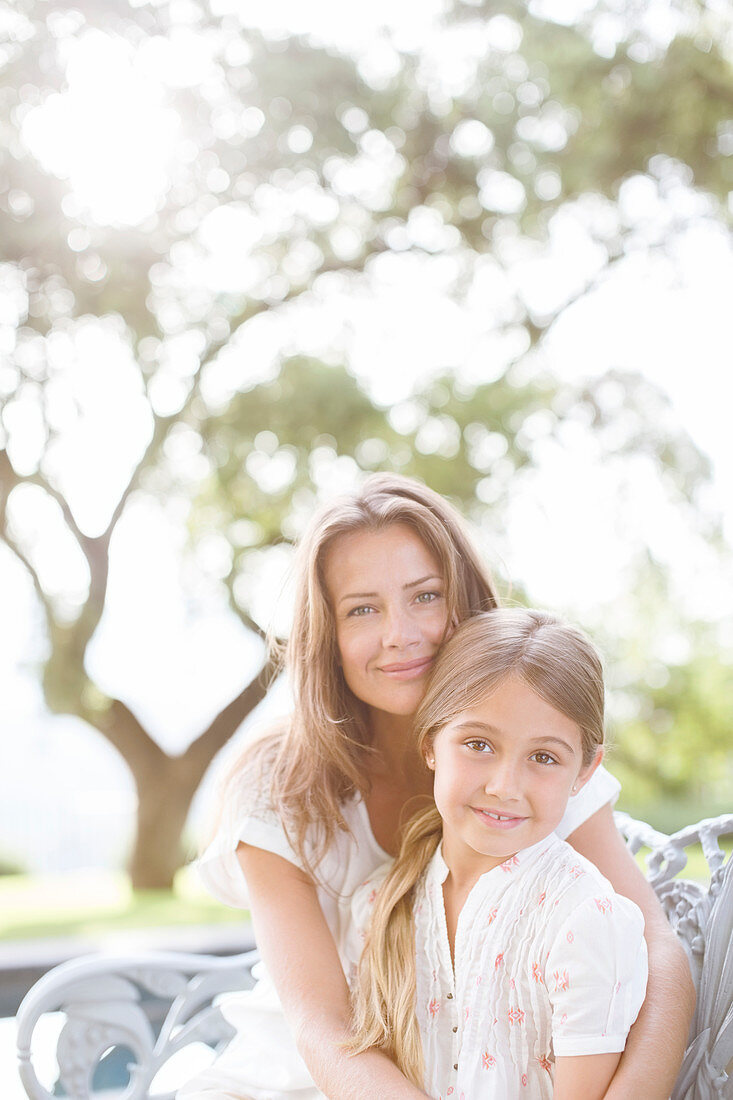 Mother and daughter hugging outdoors