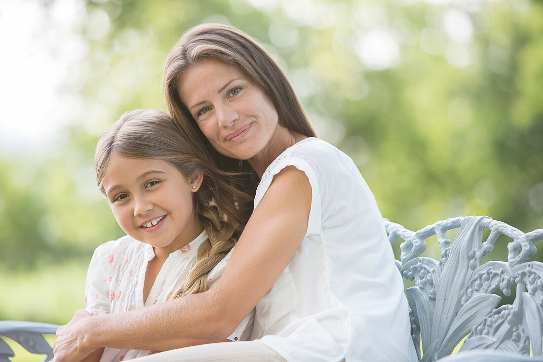 Mother and daughter hugging outdoors