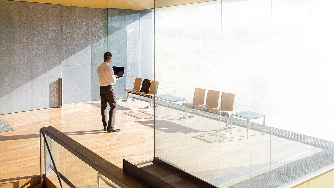 Businessman using laptop in office lobby