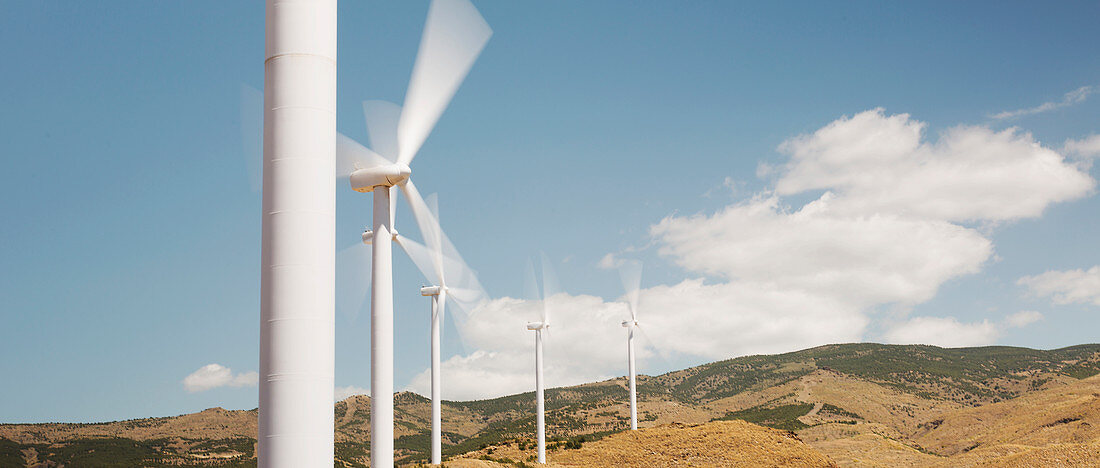 Wind turbines spinning in rural landscape