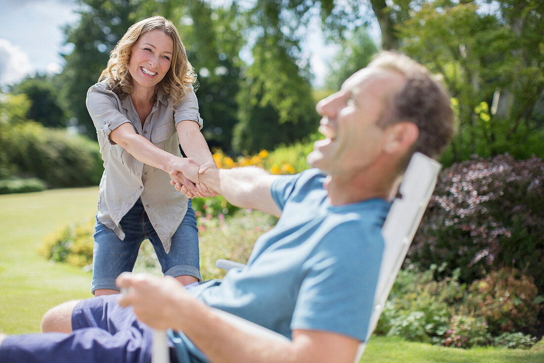 Woman pulling boyfriend out of chair